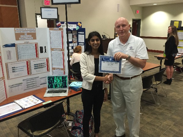 Jones congratulates a student for her accomplishments in science, technology, engineering and mathematics (STEM) at a March science fair.