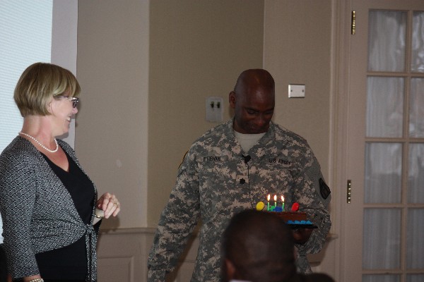 Board member Beth Kelly surprises LTC Etienne with a birthday cake at the luncheon in November. 
