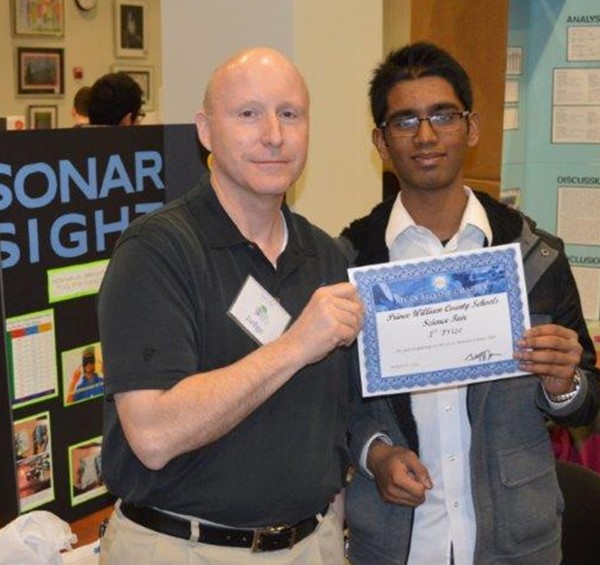 Bill Jones, chapter president, joins a student scholarship recipient during the science fair in March.