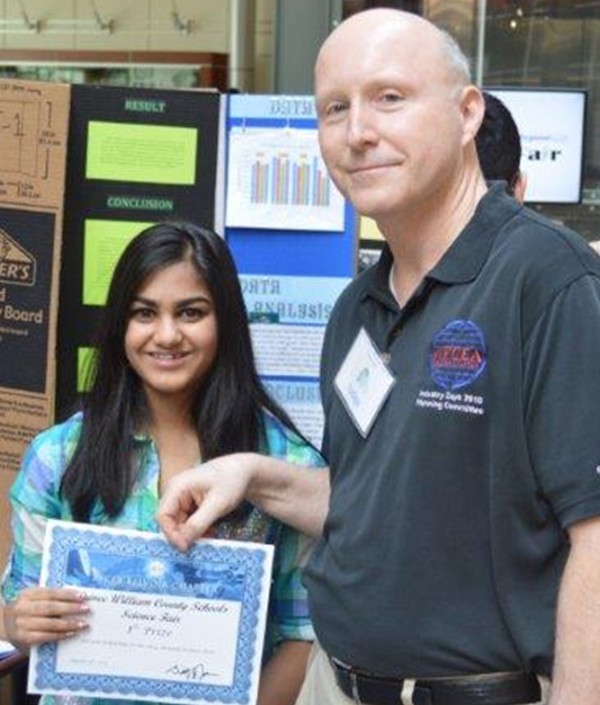 Bill Jones, chapter president, joins a student scholarship recipient during the science fair in March.