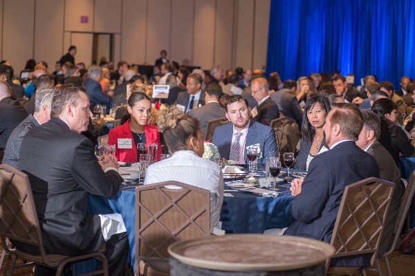 Government and industry professionals engage in discussions during the dinner fundraiser in July.
