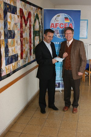 Dr. Uwe Bettscheider (l), principal of the Ernst-Moritz-Arndt-Gymnasium, Bonn, Germany, receives $1,000 teaching award from Maj. Gen. Klaus-Peter Treche, GEA (Ret.), chapter president, at the November meeting.
