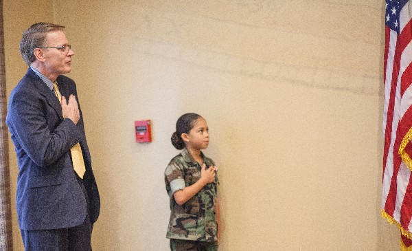 Chapter President Mark Witzel and Eagle Young Marine Pfc. Amaya Morales lead attendees in the Pledge of Allegiance to start the December chapter luncheon.