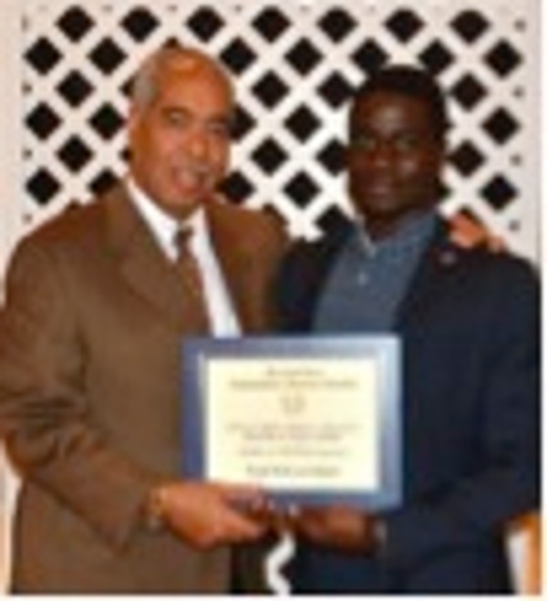 Tunji Hakeem Ogiefo (r), a junior at Morgan State University majoring in computer and electrical engineering, receives a scholarship award in September from Byron Johns of American Systems Corporation.