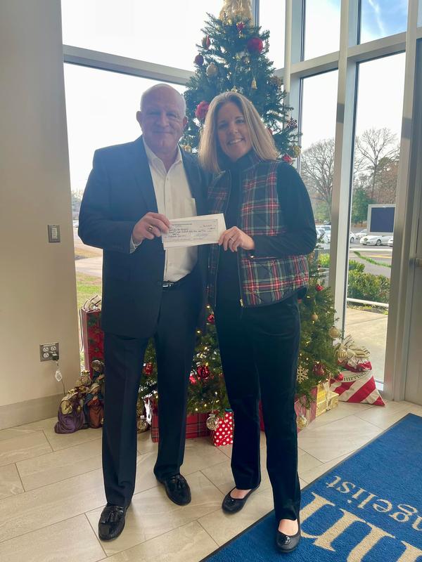 Jerry Schepers (l) and Casey Buckstaff hold up the check given to John the Evangelist School in Silver Spring, Maryland, in December.