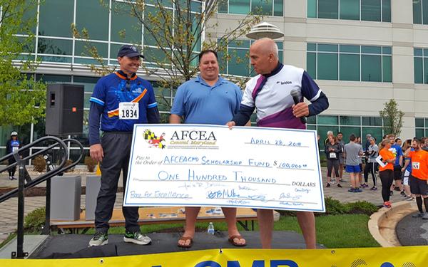 Led by Bob Mullen (r), the race committee raised a record $100,000 and presented a check at the race in April to Brian Cooper (c) and Martin Barrett, outgoing and incoming chapter presidents respectively.