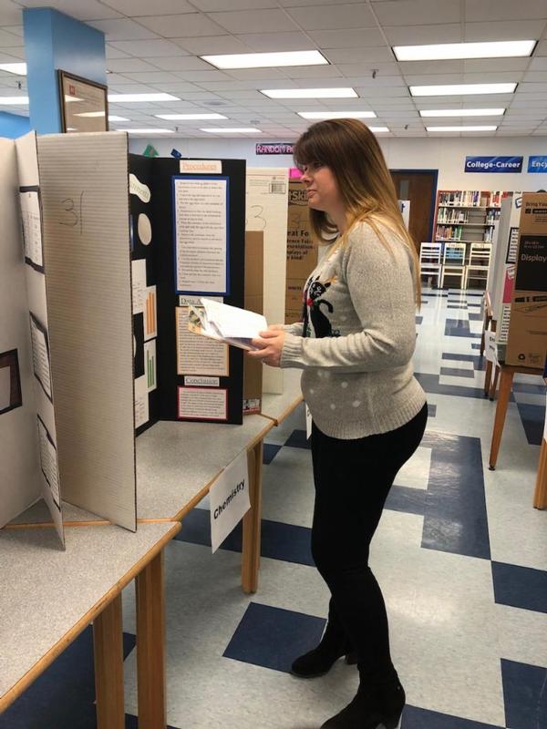 Volunteer Jennifer Havermann reviews a chemistry project at one of the December science fairs.