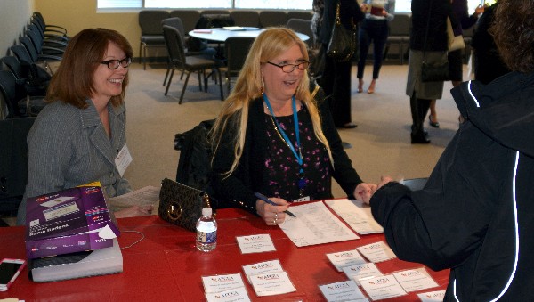 WIIG In A Minute volunteers Mary Cortes (l) and Ceil Paul, both of ProSync Technology Group, register guests at the event in March. 