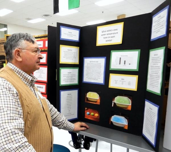 Longtime volunteer Garcia reviews a science fair presentation in December at Meade High School.