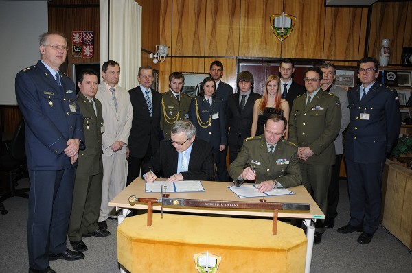 Josef Strelec, chapter president, and Col. Bohuslav Přikryl, CZA, rector of the Defense University in Brno, Czech Republic, sign a memorandum of understanding in April between AFCEA and the university, while chapter members, university representatives and members of a new student club look on. Attendees include (l-r) Col. Vlastimil Maly; Lt. Col. Petr Hruza; Miroslav Janosek, associate professor; Ladislav Nesrsta, associate professor and chapter vice president; six student club  members; Col. Martin Macko, vice rector for science and exert affairs; Brig. Gen. Rudolf Urban (Ret.), vice rector for marketing and external affairs; and Col. Libor Draan, dean, faculty of military technology.