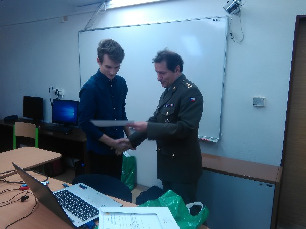 The winner of the second round of the Czech National High School Cyber Security Competition in March, Tomas Rottenberg, Boskovice High School, receives his award from Lt. Col. Petr Hruza, a member of the Czech Board and competition committee.