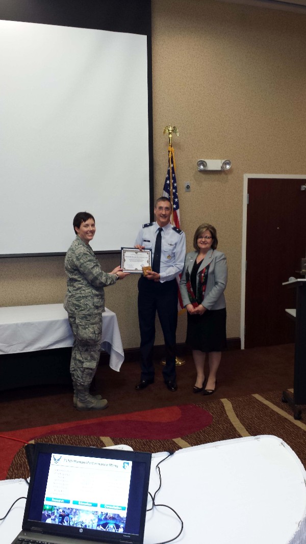 Brig. Gen. (Dr.) Timothy T. Jex, USAF (c), commander, 711th Human Performance Wing, receives a certificate of appreciation from Lt. Col. Brenda Oppel, USAF, chapter vice president of programs, and Linda Skinner, chapter president, following the generals speech at the December luncheon.
