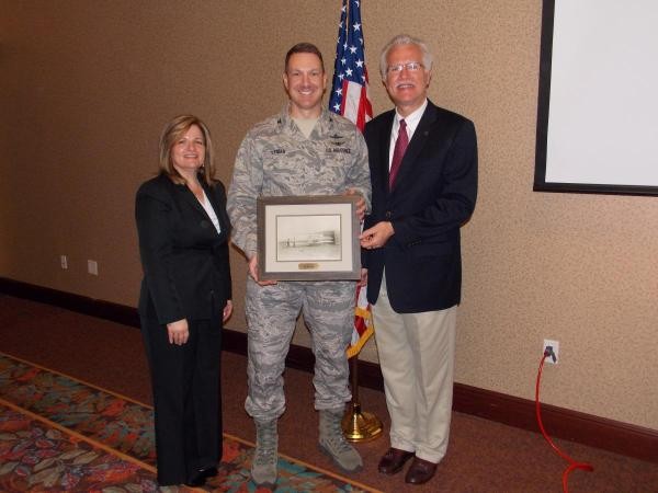 In June, Linda Skinner, chapter president, and Rick Wegmann, chapter chairman of the board, present Col. Rob Lyman, USAF, with a Wright Flyer print for his service on the chapter board.