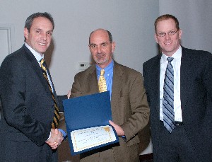 Ricky L. Peters (c), deputy director, Air, Space and Information Operations, Headquarters Air Force Materiel Command, Wright-Patterson Air Force Base, Ohio, accepts a token of appreciation from Dan Curtis (l), chapter vice president for programs, and Dave Judson (r), chapter president. Peters provided the keynote presentation at the February luncheon.
