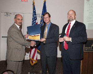 At the November Luncheon, Richard Honeywell (l), Directorate of Logistics, Air Force Materiel Command, receives a token of appreciation from Dan Curtis (c), chapter vice president for programs, and David Heart, chapter president.
