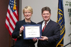 Gerald Tritle, chapter president, presents Kathy Demolet, education vice president, with an Education Service award at the April luncheon.
