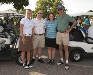 In July, Minda Moore (l) and Andrea Kunk (2nd from r) join guests at the chapter's scholarship golf tournament.