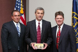 Michael Bridges (l), chapter vice president of programs, and Tritle (r) present April guest Jon Ogg with a Wright Brothers coin set as a token of appreciation for speaking at the luncheon.