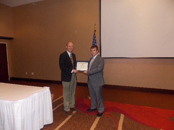 Eric Saunders (l), recipient of an Intelligence Scholarship, is congratulated by Aaron Miller, luncheon emcee and chapter officer, in January.