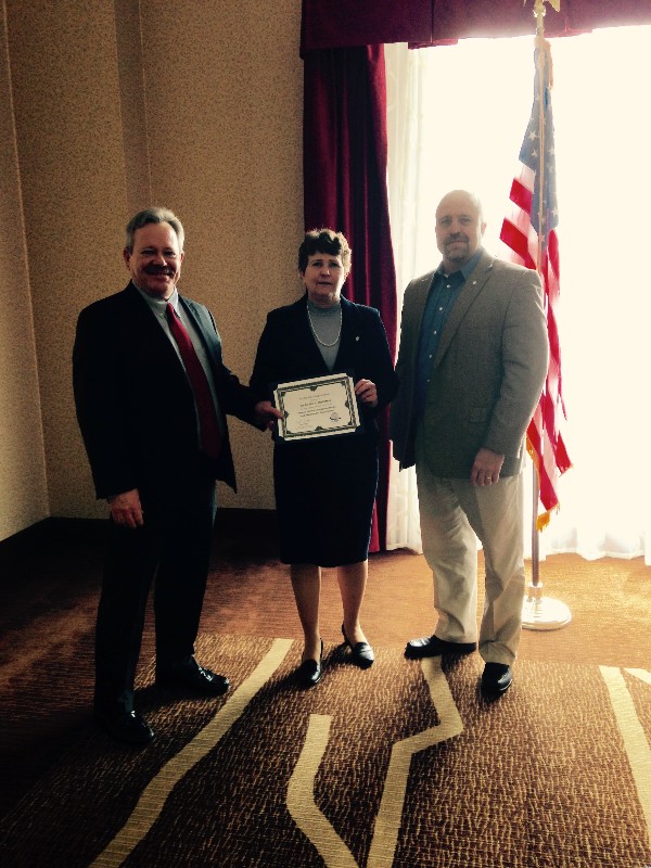 Goddard (l) presents a certificate to May speaker Dr. Eileen Bjorkman with Hart.