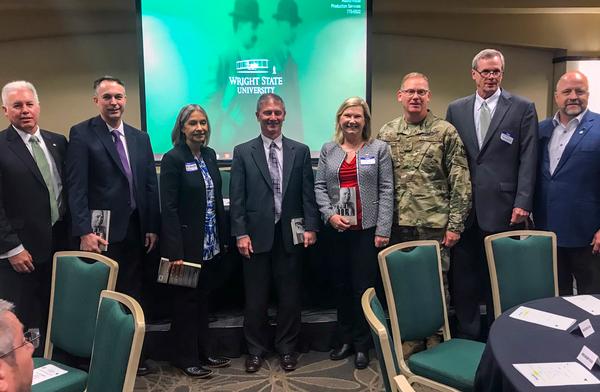 Members of a senior logistician panel pose for a group photo and receive autographed copies of Retired Army Staff Sgt. Shilo Harris' book STEEL WILL at the Fourth Annual Dayton-Wright AFCEA and Wright Brothers Logistics Officers Association Air Force Logistics IT Summit in Dayton, Ohio, in June. The panel convened to speak about Air Force logistics challenges and how data and the IT community can support. (Photo courtesy of Segue Technologies)