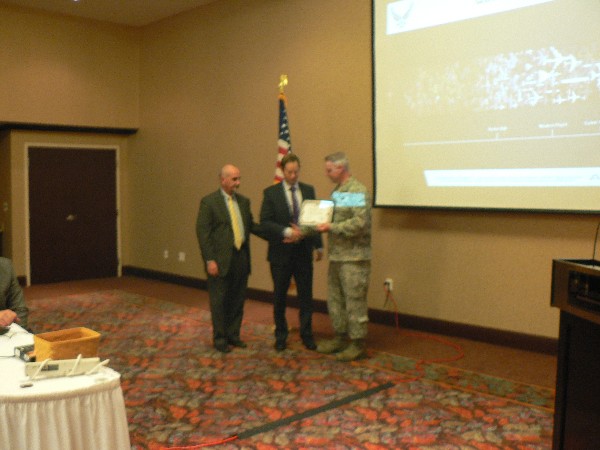 Col. Henry (r) receives a certificate of appreciation from Dan Curtis (l), chapter president, and Casey Weinstein, chapter vice president for programs, at the September meeting.