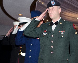 Service members salute during the opening ceremony for the Valentine's Charity Ball in February.