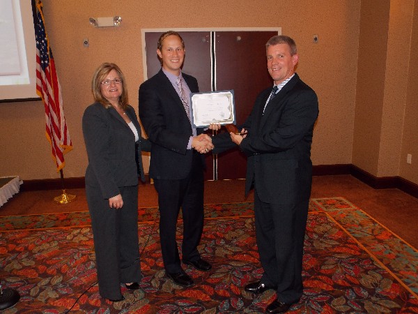 Skinner (l) and Casey Weinstein (c), chapter vice president of programs, present a certificate and coin to the August luncheon speaker Thomas A. Lockhart, deputy program executive officer for tankers, U.S. Air Force.