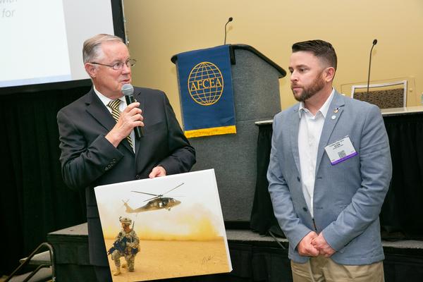 At the May TechNet Cyber event, Wallace presents Gen. Shea with a combat photo. Wallace works for Defense Department contractor Segue Technologies based in Arlington, Virginia.