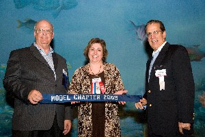 At the Joint Warfighting Conference in May, Michelle Corcoran, past chapter president, accepts the chapter's award for Model Chapter of the Year  from Kent Scheider (l), president and chief executive officer of AFCEA International, and Paul Cofoni, AFCEA International board chair.