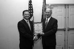 Richard Novak (l), CEO of Novak and Associates, receives a gift of thanks, from Doucet, for his personal lifetime membership. His company supports all of the Chapters special events and luncheons. 
