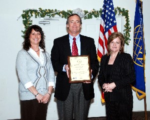 Linda Skinner (r), chapter vice president for corporate membership, provides a plaque to Julie Eitniear and Tom Mayer, both from Manpower Inc., in recognition of the company's new corporate membership at the November meeting.