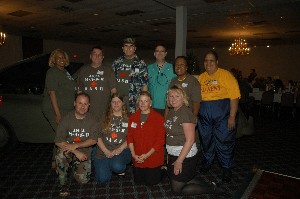 The M*A*S*H Bash volunteers pose in front of Bob Potts' 1941 staff car at the August event.