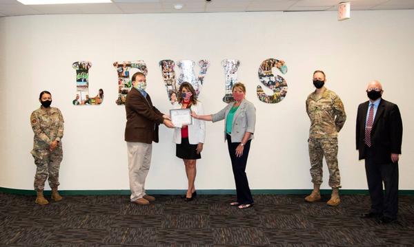 (Pictured from l-r) 1st Lt. Renee Hawn, USAF, chapter vice president of finance; Jason Driver, principal, Addie R. Lewis School, Valparaiso, Florida; Elaine LaJeunesse, liaison, Eglin School; Carol Joyner, vice president of education; Col. Scott Weed, USAF, chapter president; and Dennis Biling, deputy director, 96th Mission Support Group, pose for a photo at the August event.