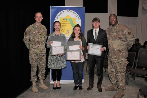 In February, Lt. Col Scott Weed, USAF, chapter president (far l), and 1st Lt. Vernon Peoples, USAF (far r), present awards to (from center l-r) Quinnlynn Holsinger, Aurora Mendenhall, and Charles Sherwin, during the February ceremony. Awardee Joshua Pruitt is not pictured.