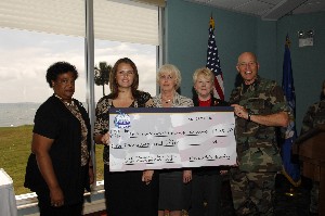 Col. Buddy Blanke, USAF (r), presents a check for $1000 to members of the science department of Avalon Middle School for use in their robotics competition.