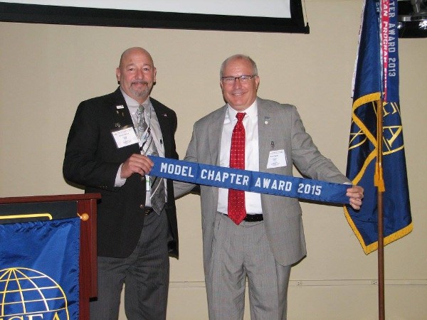 Martin Harbolt (l) and Brad Genet, the chapter's vice chairman of the board, accept the 2015 Model Chapter Award at the June meeting.