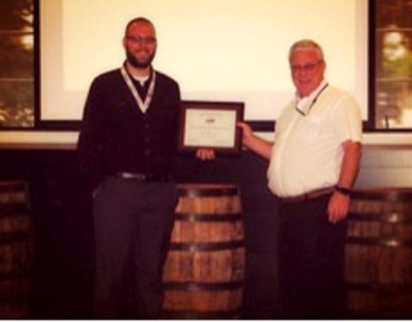 Chapter President Steven Dalton (r) presents a certificate to guest speaker Bryan Bain, change and release manager, United Parcel Service, at the Young AFCEAN meeting in August. 