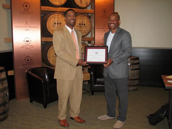 Vice President of Young AFCEAN Affairs Derek Massey presents an award to March guest speaker Jide Aniyikaiye, enterprise solutions architect for DXC Technology.