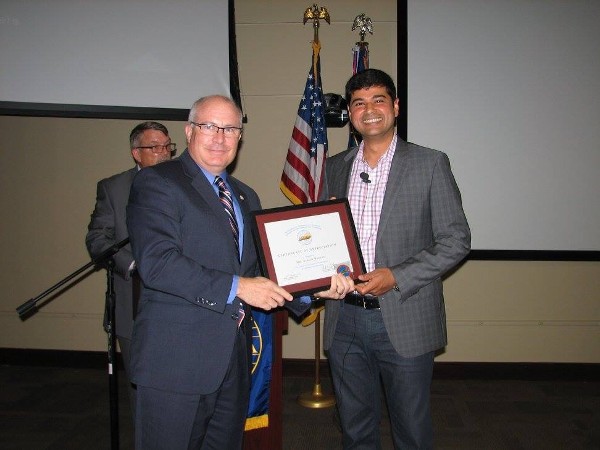 Brad Genet, chapter vice chairman of the board (l), presents an award to guest speaker Badani at the September meeting.