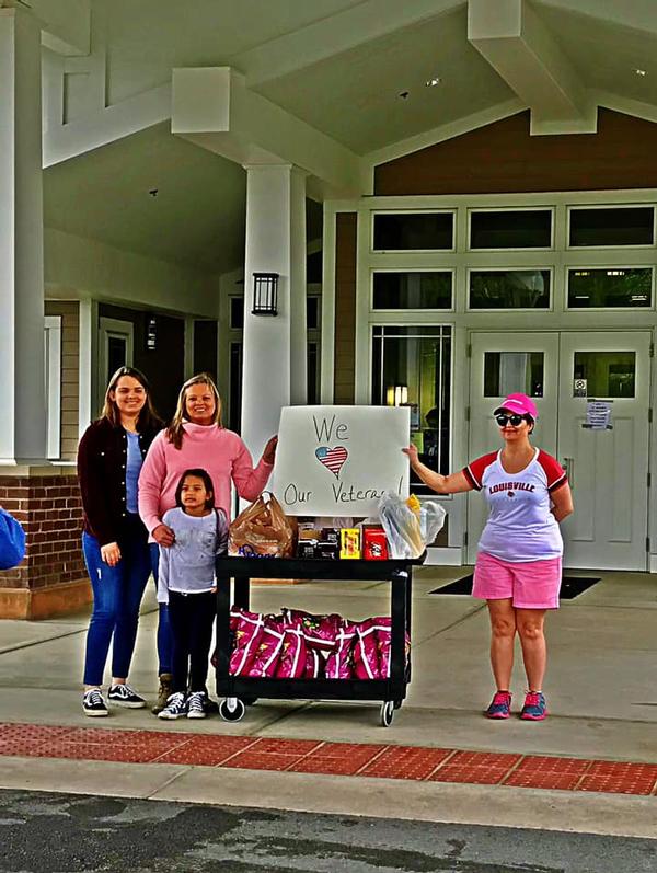 (From l-r) Jessica Johnson and family, and Gina Dowell, chapter women outreach leader, cheer on the veterans for the Spirit Parade in April.
