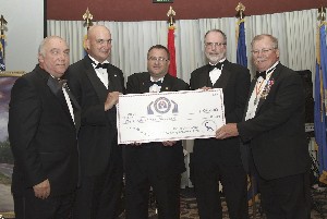 At the 5th Annual Support Our Heroes Military Ball, Derek Donovan (2nd from l) from the Fisher House Foundation receives a check from Bob Fasulo (l), president, Association of the United States Army; Brian Abbe (c), president, Association of Old Crows; Chuck Strimpler (2nd from r), chapter president; and Ed Carnes, president, Army Aviation Association of America.