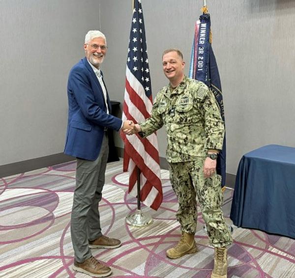 Doug Rausch, program director, Center for Cyber Security Education, Bellevue University, Bellevue, Nebraska, shakes hands with Capt. Brad Melichar, USN, chapter president. Rausch was the speaker for the May luncheon.  As a prior speaker, instead of receiving a Greater Omaha Chapter coin, Rausch was afforded the opportunity to select a charity of choice for a chapter donation for addressing the chapter.