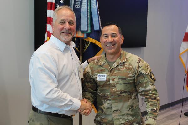 U.S. Southern Command J6 Director and Chief Information Officer Joe Tragakis (r) accepts AFCEA Greater Tampa Bay Challenge Coin from Col. Philip Alvarez, chapter president, in September.