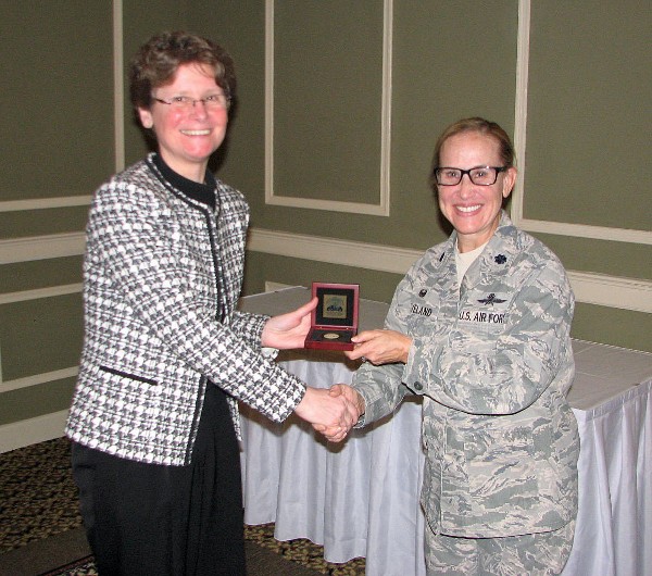 Chapter President Lt. Col. Sarah Cleveland, USAF (r), presents a chapter coin to April luncheon speaker Theresa Giorlando, principal cyber engineer, MITRE Corporation.