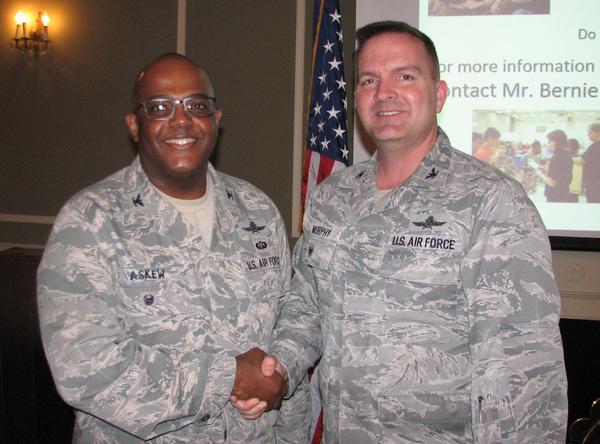 Col. Isreal L. Askew, USAF, director, Cyber Operations Integrated Planning Element, US Cyber Command located at U.S. Strategic Communications, Offutt Air Force Base, Nebraska (l), is pictured with Col. Sean Murphy, USAF, chapter president. Col. Askew receives a chapter coin for speaking at the February luncheon.