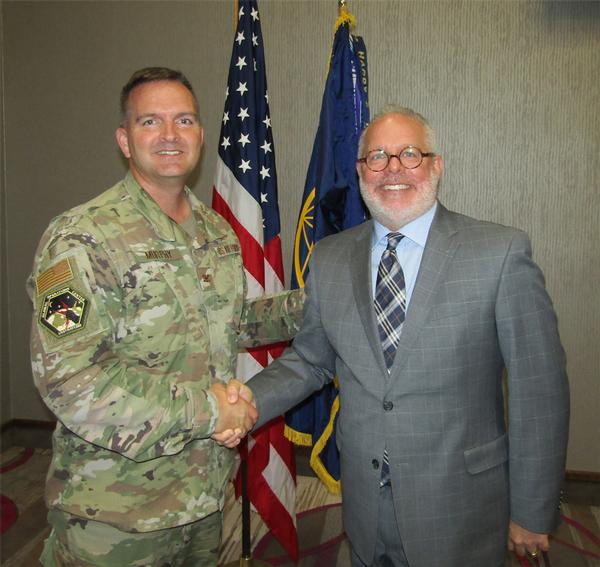 Col. Sean Murphy, USAF, chapter president (l), shakes hands with Jeffrey Phelan, portfolio lead for milCloud 2.0, General Dynamics Information Technology, Falls Church, Virginia. Phelan was the speaker for the October luncheon and received a chapter coin for his presentation.