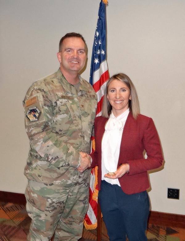 Col. Sean Murphy, USAF, chapter president (l), shakes hands with Hannah Birgé, director, Water and Agriculture Programs, The Nature Conservancy, Omaha, Nebraska.  Birgé was the speaker for the February luncheon and received a Greater Omaha Chapter coin for addressing the chapter.