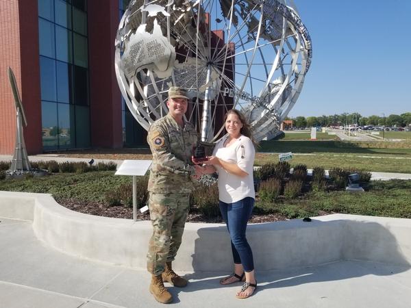 In September, Col. Sean Murphy, USAF, chapter president (l), shakes hands with Jennifer Havenner, chapter vice president of diversity, and presents her with the Distinguished Young AFCEAN Honoree Award for 2019 in front of the new U.S. Strategic Command's Command and Control Facility at Offutt Air Force Base, Nebraska. 