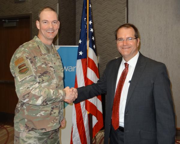 Col. Larry Fletcher, USAF (l), chapter president, shakes hands with James Taylor (r), deputy executive director, Nebraska Defense Research Corporation. Taylor was the speaker for the March Luncheon and will be the first to receive a Greater Omaha Chapter new commemorative coin for addressing the chapter.